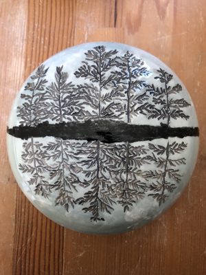 Round dish with a tree and its reflection illustration